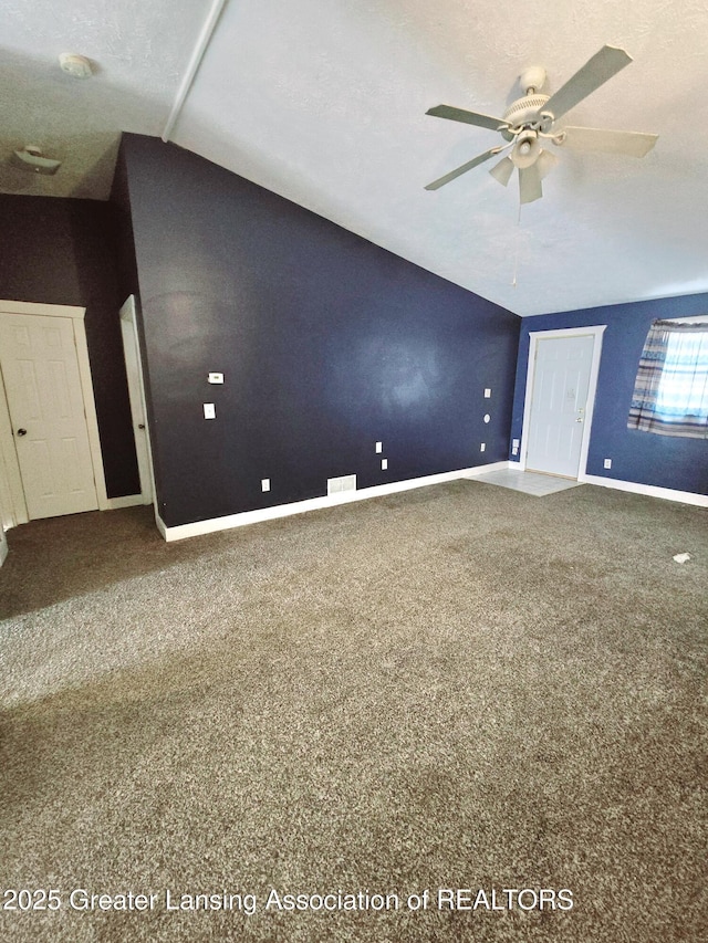 spare room with vaulted ceiling, ceiling fan, and carpet