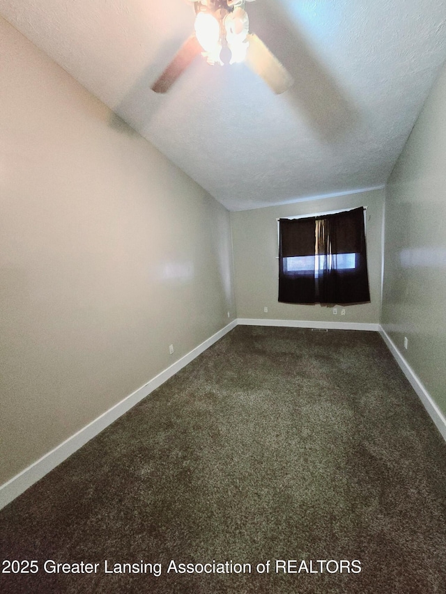 carpeted spare room featuring ceiling fan, vaulted ceiling, and a textured ceiling