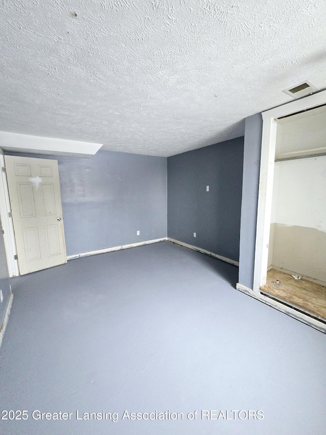 interior space featuring a textured ceiling and concrete floors