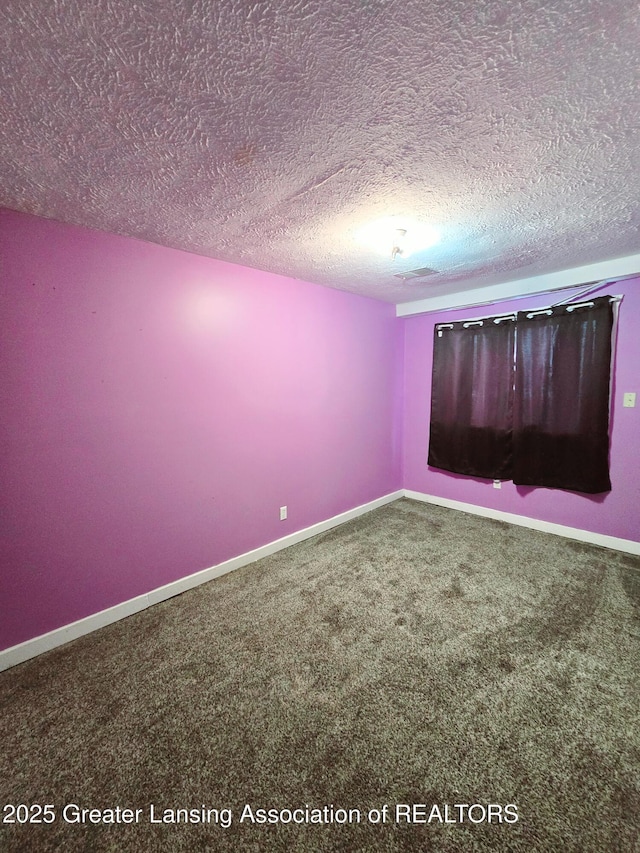 unfurnished room featuring carpet flooring and a textured ceiling