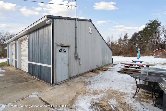 snow covered structure featuring a garage