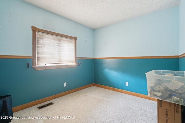 carpeted spare room with a textured ceiling