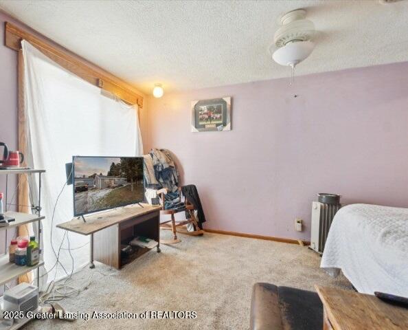 bedroom featuring light colored carpet and a textured ceiling