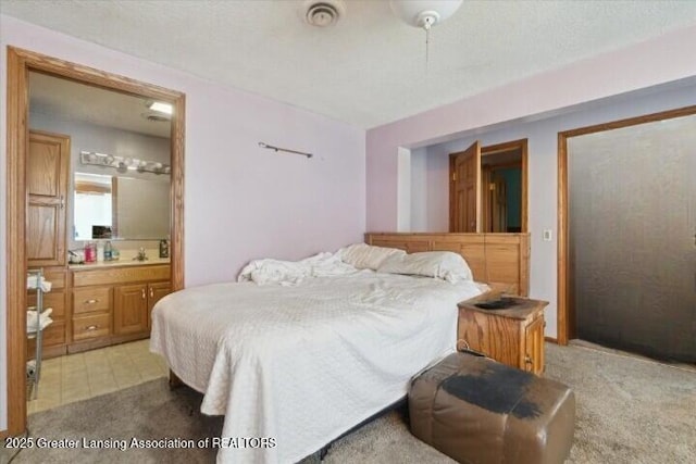 bedroom featuring connected bathroom and light carpet