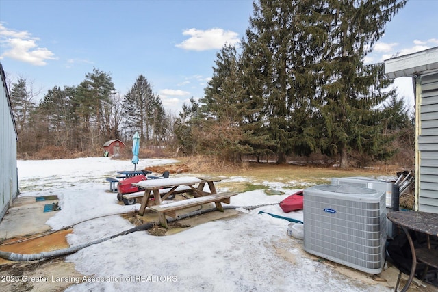 snow covered patio with cooling unit