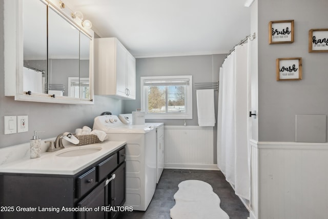 laundry area featuring sink, washer and clothes dryer, and cabinets