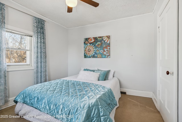 carpeted bedroom with crown molding, ceiling fan, and a textured ceiling