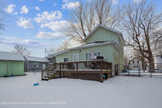 snow covered rear of property with a wooden deck