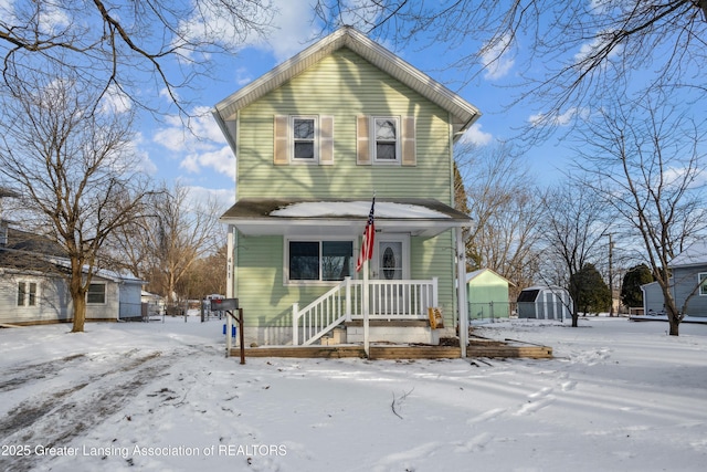 view of front property featuring a shed and covered porch