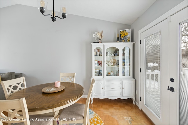 dining area featuring french doors, vaulted ceiling, and light parquet floors