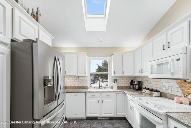 kitchen with white cabinetry, sink, decorative backsplash, light stone countertops, and white appliances