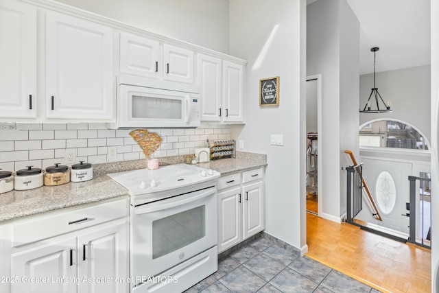 kitchen featuring light stone counters, white cabinets, white appliances, and decorative backsplash