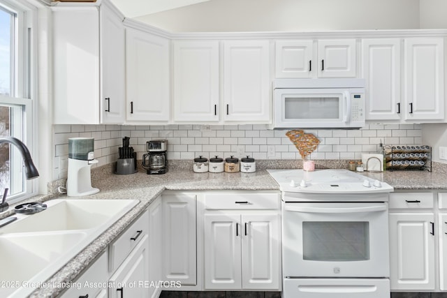 kitchen with white cabinetry, white appliances, sink, and backsplash