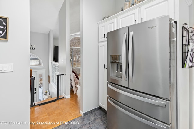 kitchen featuring stainless steel fridge, dark parquet floors, and white cabinets