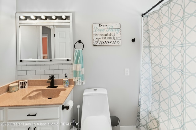 bathroom with tasteful backsplash, vanity, and toilet