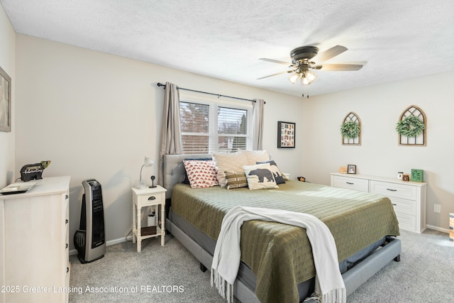 bedroom with ceiling fan, light colored carpet, and a textured ceiling