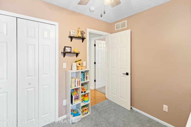 playroom featuring a textured ceiling and ceiling fan