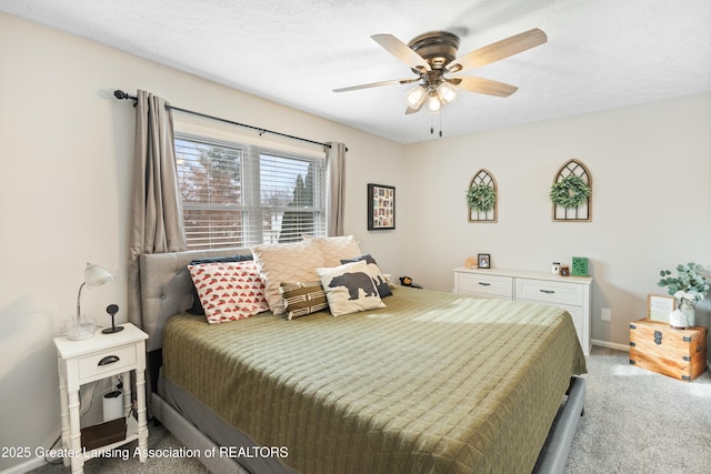 carpeted bedroom with ceiling fan and a textured ceiling