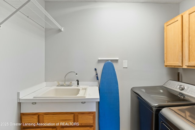 washroom featuring sink, cabinets, and washing machine and clothes dryer