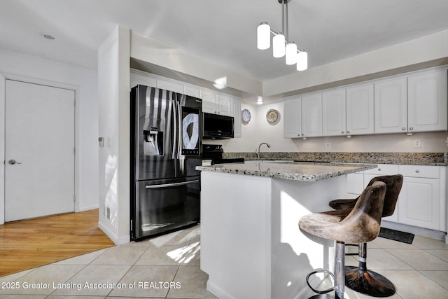 kitchen with pendant lighting, white cabinetry, a center island, stainless steel refrigerator with ice dispenser, and light tile patterned flooring