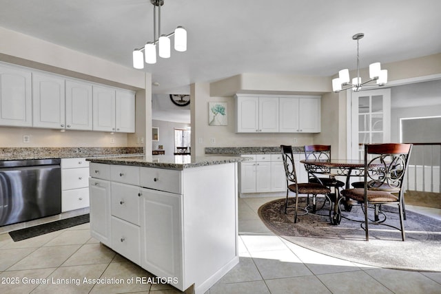 kitchen with light tile patterned flooring, a kitchen island, decorative light fixtures, white cabinetry, and dishwasher