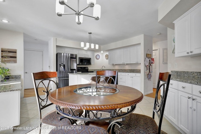 dining space featuring a notable chandelier, sink, and light tile patterned floors