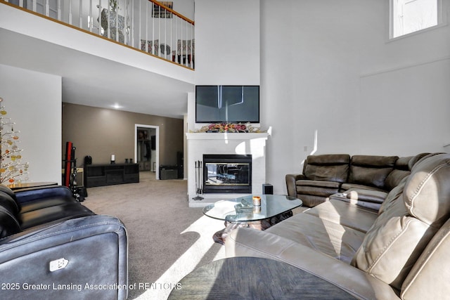 living room with a towering ceiling and carpet floors