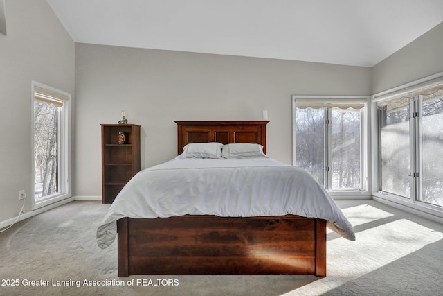 bedroom with multiple windows, light colored carpet, and lofted ceiling