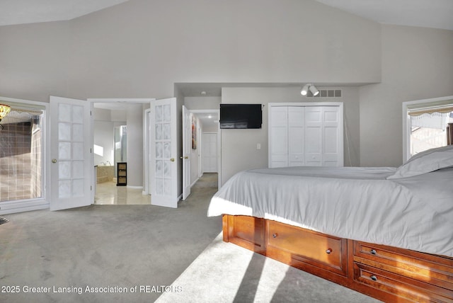 bedroom with light carpet and high vaulted ceiling