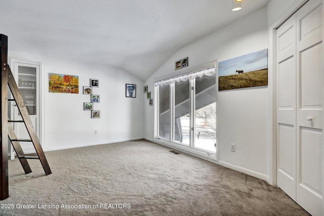 unfurnished room featuring vaulted ceiling and carpet floors