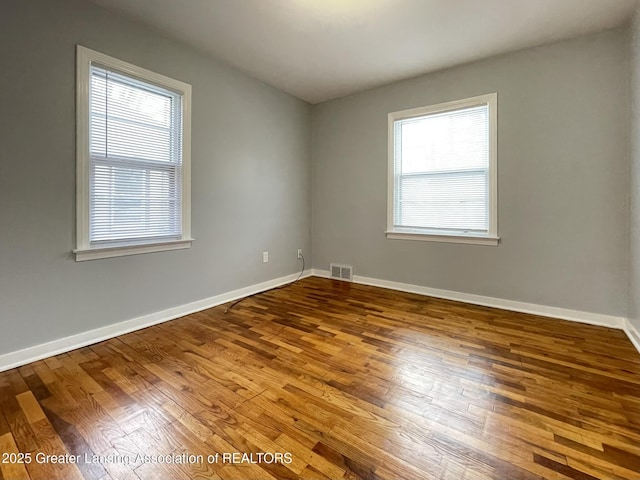 unfurnished room with wood-type flooring and plenty of natural light