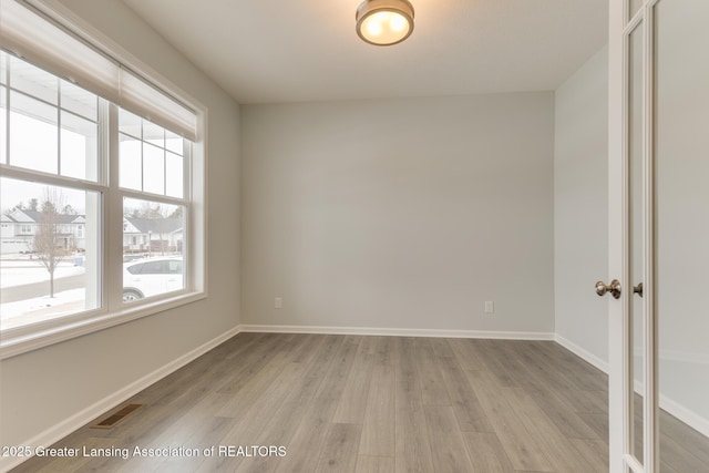 unfurnished room with plenty of natural light and light hardwood / wood-style flooring