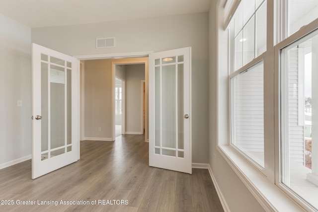 spare room with light hardwood / wood-style flooring and french doors