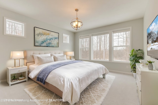 bedroom with light carpet and an inviting chandelier