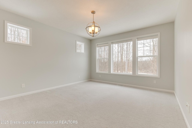 unfurnished room with a chandelier and carpet flooring