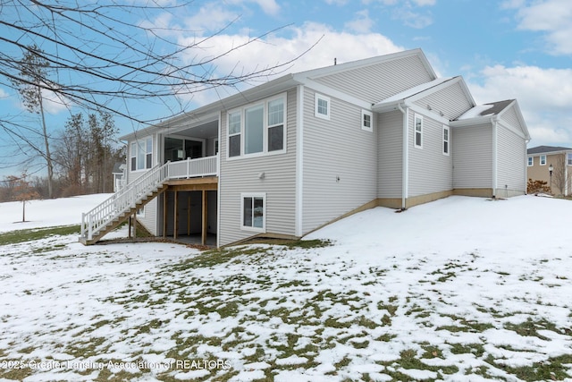 view of snow covered back of property