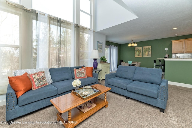 carpeted living room featuring sink and a notable chandelier