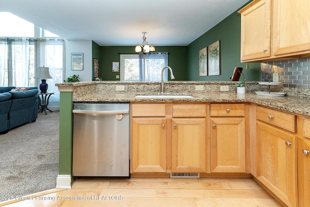 kitchen with light stone counters, sink, decorative backsplash, and stainless steel dishwasher