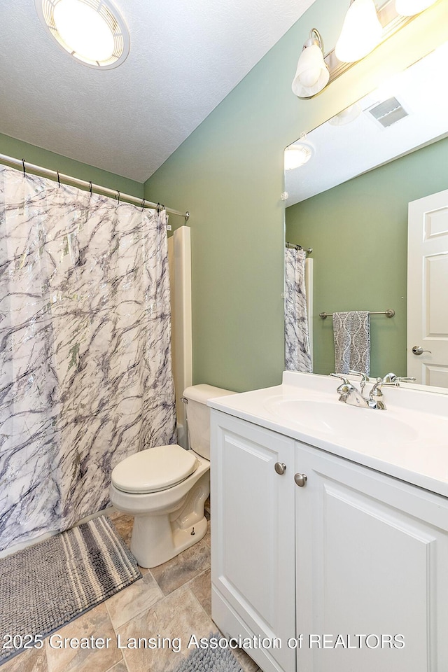 bathroom with vanity, curtained shower, and toilet