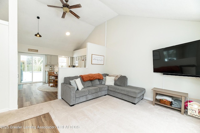 living room with ceiling fan, high vaulted ceiling, and light wood-type flooring