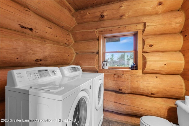 clothes washing area featuring log walls, wood ceiling, and independent washer and dryer