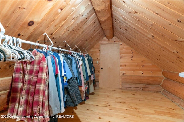 spacious closet featuring vaulted ceiling with beams and hardwood / wood-style flooring