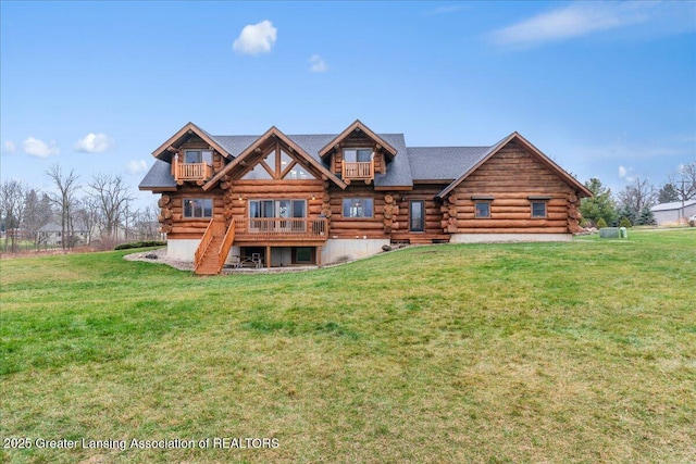 back of property featuring a balcony and a lawn