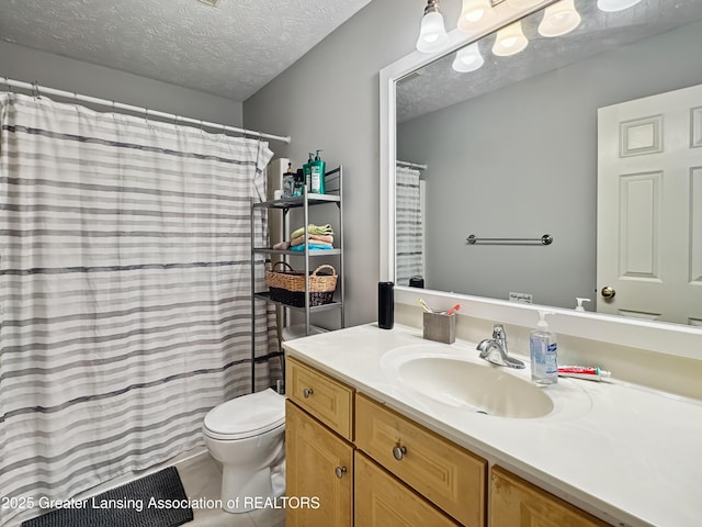 bathroom featuring vanity, a textured ceiling, and toilet