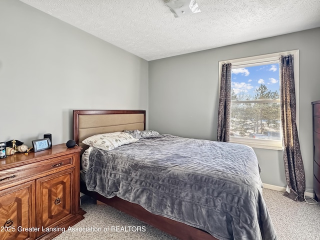 bedroom with light carpet and a textured ceiling