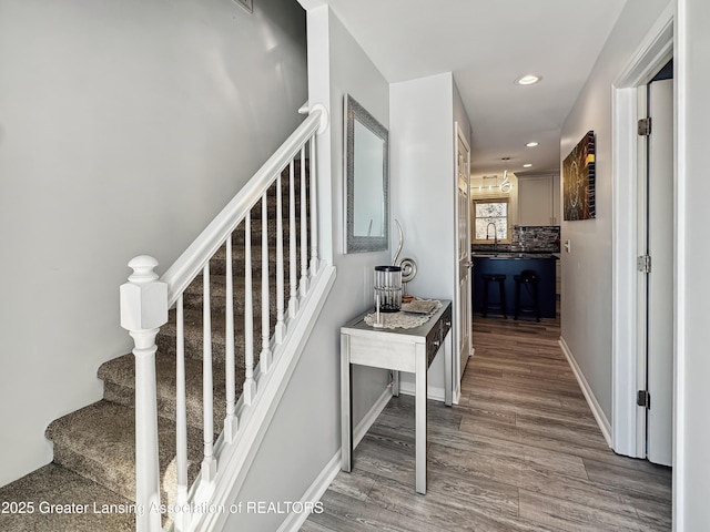 stairway with hardwood / wood-style flooring and sink