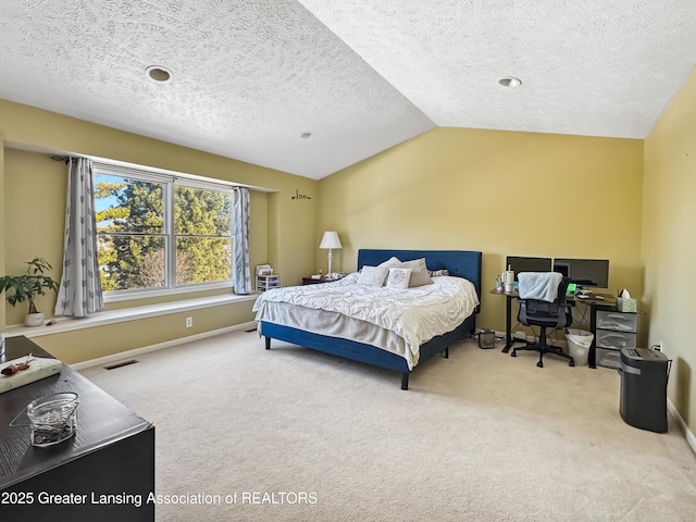 bedroom with lofted ceiling, carpet flooring, and a textured ceiling