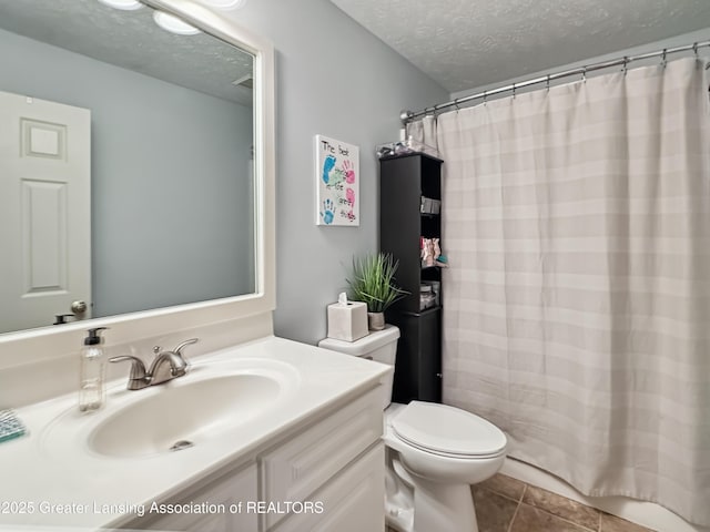 bathroom featuring toilet, a shower with curtain, a textured ceiling, vanity, and tile patterned flooring