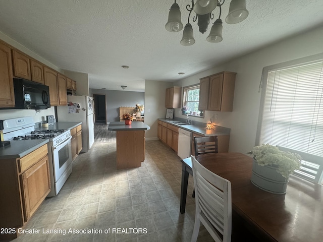 kitchen with a center island, sink, a textured ceiling, and white appliances