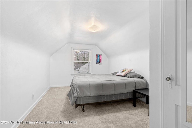 bedroom featuring vaulted ceiling and light colored carpet